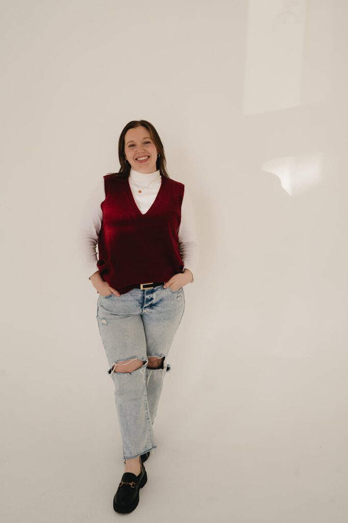 Sarah Roberson of Serendipity Records Content Co. stands against white wall for branding photos for her Las Cruces wedding content creator business.